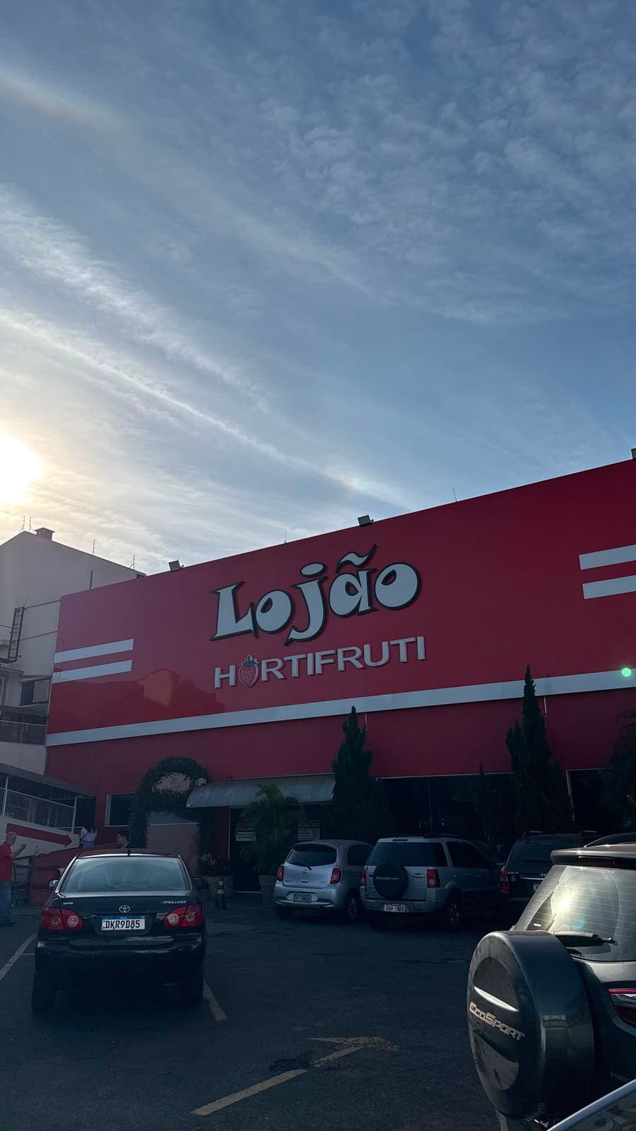 Fachada do Lojão e o estacionamento no fim de tarde